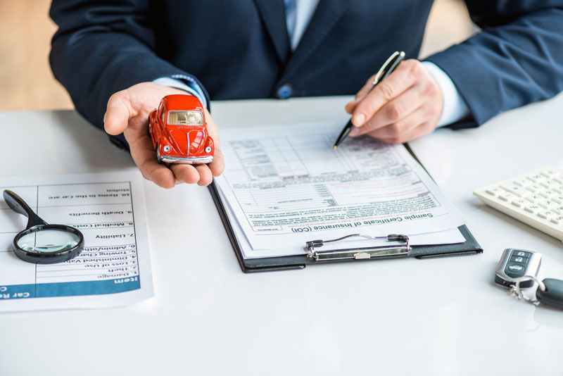 man signing auto insurance paperwork